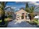 Charming single-story home featuring a well-manicured lawn, a bright orange front door, and beautiful palm trees at 491 Goldenmoss Loop, Ocoee, FL 34761