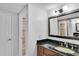 This bathroom includes a granite countertop, wood cabinets, and a walk-in shower with beautiful tile at 530 E Central Blvd # 102, Orlando, FL 32801