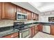 This kitchen features dark wood cabinets, black granite countertops, and stainless steel appliances at 530 E Central Blvd # 102, Orlando, FL 32801