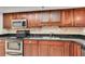 Kitchen featuring granite countertops, stainless steel appliances, and dark wood cabinets at 530 E Central Blvd # 102, Orlando, FL 32801