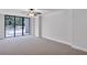 A large living room has neutral carpet, a ceiling fan, and glass doors with black frames at 530 E Central Blvd # 102, Orlando, FL 32801