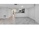 Open-concept living room boasts light gray tile flooring, neutral walls, and a breakfast bar overlooking the kitchen at 530 E Central Blvd # 102, Orlando, FL 32801