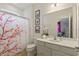 Clean bathroom with shower and cherry blossom decor at 5414 Oakgrain Ct, Davenport, FL 33837
