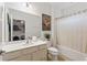 Clean bathroom with white vanity, toilet, and bathtub with beige shower curtain at 5414 Oakgrain Ct, Davenport, FL 33837