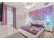 Bright bedroom with a white bed frame and purple bedding, featuring a sparkly accent wall at 5414 Oakgrain Ct, Davenport, FL 33837