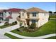 Two-story house with a tan exterior, landscaped lawn, and a two-car garage at 5414 Oakgrain Ct, Davenport, FL 33837
