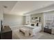 Spacious main bedroom with tray ceiling, neutral colors, bench at the end of the bed, and ensuite bathroom at 5994 Painted Leaf Dr, Winter Garden, FL 34787