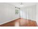 Bright bedroom featuring hardwood floors, closet, window and a decorative light fixture at 7943 Snowberry Cir, Orlando, FL 32819