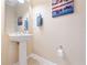 Small bathroom with pedestal sink, wall-mounted mirror and decorative art at 8013 Cool Breeze Dr # 116, Orlando, FL 32819