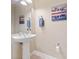 Small bathroom with pedestal sink, wall-mounted mirror and decorative art at 8013 Cool Breeze Dr # 116, Orlando, FL 32819