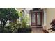 Beautiful front entrance with double doors, columns, lush greenery, and manicured landscaping at 8327 Via Verona, Orlando, FL 32836