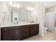Bathroom featuring dual sinks, a large mirror, and a separate toilet/shower area, offering convenience and style at 10231 Beechwood Ln, Orlando, FL 32832