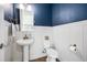 Charming powder room with pedestal sink, blue accent wall, and decorative fixtures at 10231 Beechwood Ln, Orlando, FL 32832