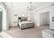 Bright bedroom featuring a tray ceiling, modern chandelier, and a bed with a mirrored headboard at 10231 Beechwood Ln, Orlando, FL 32832