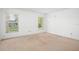 Inviting bedroom featuring two windows for natural light and neutral carpeting at 10305 Licorice Way, Orlando, FL 32821