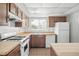 Cozy kitchen featuring wood cabinets, tile floor, standard appliances, and a bright window at 10305 Licorice Way, Orlando, FL 32821