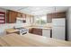 Kitchen featuring wood cabinets, standard appliances, tile floor, and a bright window at 10305 Licorice Way, Orlando, FL 32821