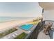 Balcony view of fenced pool, beach, and ocean beyond at 111 S Atlantic Ave # 301, Ormond Beach, FL 32176