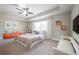 Staged bedroom featuring neutral walls, tray ceiling, plush carpet, and window for natural lighting at 1217 E Muriel St, Orlando, FL 32806