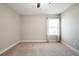 Bright bedroom with neutral walls and carpet features a window with blinds and decorative curtains at 1217 E Muriel St, Orlando, FL 32806