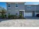 Gray two-story townhouse showcasing front door, two-car garage, and manicured landscaping at 1217 E Muriel St, Orlando, FL 32806