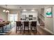 Open concept kitchen with white cabinetry, stainless appliances, island, and adjacent dining area at 1217 E Muriel St, Orlando, FL 32806