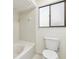 An all-white bathroom includes a tub and shower combination, plus a window above the toilet at 124 Loon Ct, Daytona Beach, FL 32119