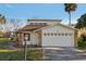 Charming home exterior features stone accents and a two-car garage with decorative windows at 124 Loon Ct, Daytona Beach, FL 32119