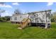 Gray manufactured home with wooden steps and a grassy lawn at 1356 Cupid Ave, Christmas, FL 32709