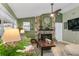 Living room showcasing a stone fireplace, a clock and a fan on a high ceiling at 1417 Borg Ln, Winter Springs, FL 32708