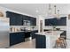 Modern kitchen with navy cabinets, island, and stainless steel appliances at 1977 Tohoqua Blvd, Kissimmee, FL 34744