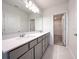 Bathroom with double vanity, stone countertops, large mirror, and walk-in closet access at 2206 Lovely Ln, Davenport, FL 33897
