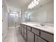 Modern bathroom features a double vanity with stone countertops and tiled shower at 2206 Lovely Ln, Davenport, FL 33897