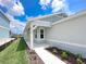 A welcoming front entrance featuring a covered porch, neutral exterior paint, and meticulously landscaped garden beds at 2206 Lovely Ln, Davenport, FL 33897