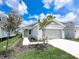 Charming single-story home with a well-manicured lawn, a two-car garage, and a walkway to the front door at 2206 Lovely Ln, Davenport, FL 33897