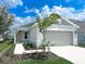 Charming single-story home with a well-manicured lawn, a two-car garage, and a walkway to the front door at 2206 Lovely Ln, Davenport, FL 33897