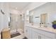 Modern bathroom featuring double sinks, quartz countertop, and a glass-enclosed shower at 2429 Volunteer Ave, Kissimmee, FL 34744