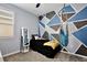 Stylish bedroom featuring geometric wall design and unique hanging chair for a trendy aesthetic at 2429 Volunteer Ave, Kissimmee, FL 34744