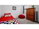 Cozy bedroom featuring a red bedspread, gray carpet, and a wooden wardrobe for ample storage at 2429 Volunteer Ave, Kissimmee, FL 34744
