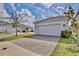 Exterior view of a house with an attached two-car garage and paved driveway at 2429 Volunteer Ave, Kissimmee, FL 34744