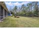 Large fenced backyard featuring lush green lawn, outdoor seating, and mature trees at 2438 River Rise Ct, Orlando, FL 32828
