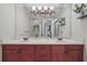 Bathroom featuring a double vanity, large mirror, and elegant decor with greenery at 2438 River Rise Ct, Orlando, FL 32828