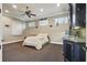 Spacious bedroom with a bed, ceiling fan, kitchenette, and large windows providing natural light at 2438 River Rise Ct, Orlando, FL 32828