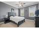 Gray bedroom featuring a bed, nightstand, and two windows with natural light at 2438 River Rise Ct, Orlando, FL 32828