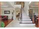 Elegant foyer featuring hardwood and tile flooring with a staircase and views to the living room at 2438 River Rise Ct, Orlando, FL 32828