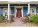 Inviting front porch with red front door and decorative potted plants at 2438 River Rise Ct, Orlando, FL 32828