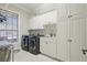 A well-equipped laundry room with ample storage, modern washer and dryer, and a sink at 2438 River Rise Ct, Orlando, FL 32828