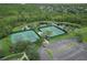 Aerial shot of the tennis courts and surrounding landscape, highlighting the community's recreational amenities and green spaces at 2438 River Rise Ct, Orlando, FL 32828
