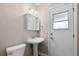This bathroom features a pedestal sink, toilet, and framed mirror and is freshly painted at 309 Oakwood Ct, Lake Mary, FL 32746