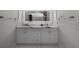 Bright bathroom featuring a dual-sink vanity with marble countertop and illuminated mirror at 309 Oakwood Ct, Lake Mary, FL 32746
